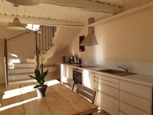 a kitchen with white cabinets and a sink and a potted plant at le bastidon in Villars