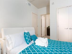 een wit bed met blauwe kussens in een slaapkamer bij 2BR Fully Furnished Apartment in downtown - Great location apts in Philadelphia