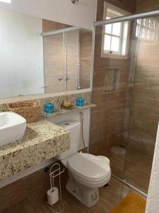 a bathroom with a toilet and a sink and a shower at Chalé Château do Luí in Monte Verde +23 photos