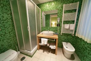 a green bathroom with a sink and a toilet at Citta' Dei Papi in Anagni