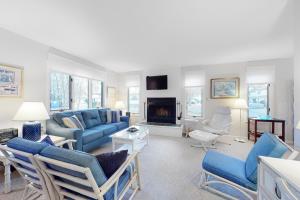 a living room with blue furniture and a fireplace at Bethany Pines -- 412 Bethany Drive in Bethany Beach