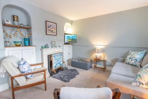 a living room with a couch and a fireplace at Dolphin Cottage in Brixham
