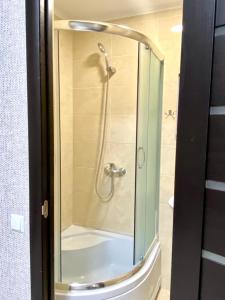 um chuveiro com uma porta de vidro na casa de banho em Apartment room-біля вокзалу-недалеко від центру em Lviv