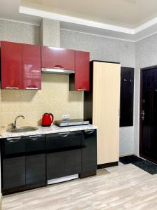 a kitchen with red cabinets and a sink at Apartment room-біля вокзалу-недалеко від центру in Lviv
