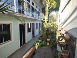 a courtyard with potted plants on the side of a building at Airport Pousada in Cabo Frio