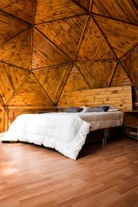 Bett in einem Zimmer mit Holzdecke in der Unterkunft GLAMPING LA CIMA NEUSA in Casablanca