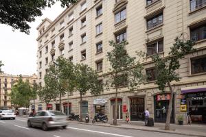 ein großes Gebäude an einer Stadtstraße mit Autos in der Unterkunft Casa Cosi - Casanova 4 in Barcelona