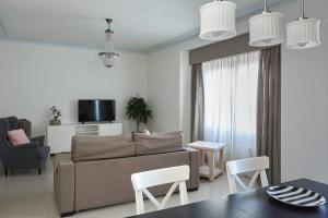 ein Wohnzimmer mit einem Sofa, einem Tisch und Stühlen in der Unterkunft Casa Cosi - Casanova 4 in Barcelona