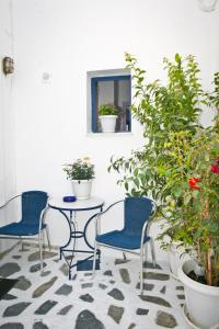 a patio with two chairs and a table and potted plants at Gorgona Studios in Livadion