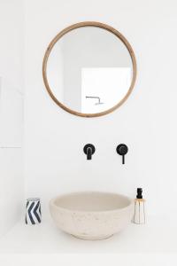 a bathroom with a round mirror and a sink at Sole Suites in Sorrento