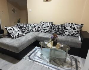 ein Wohnzimmer mit einem Sofa mit Kissen und einem Tisch in der Unterkunft Apartman Kika 1 in Valjevo