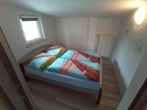 a small bedroom with a bed with a colorful comforter at Spacious Bungalow near Sea in Grundshagen in Grundshagen