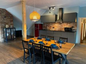 a dining room table with chairs and a kitchen at Centrum Bieszczad in Lutowiska