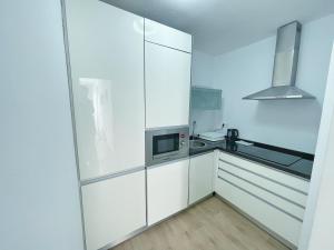 Una cocina con gabinetes blancos y un microondas. en Apartamento Soho centro malaga, en Málaga 4 fotos más