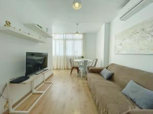 Una sala de estar con un sofá y un televisor de pantalla plana. en Apartamento Soho centro malaga, en Málaga