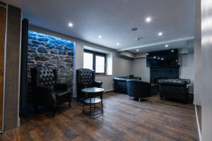 a barbershop with leather chairs and a stone wall at The Swan Inn in Stranraer