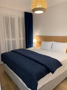 sypialnia z dużym łóżkiem i niebieskim kocem w obiekcie Apartamenty Bliska 33 w Bielsku Białej