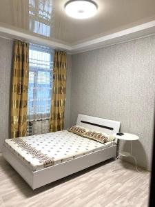 a bedroom with a bed and a table and a window at Apartment room-біля вокзалу-недалеко від центру in Lviv