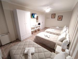 a bedroom with two beds and a desk in it at Pensión Atenea Pilgrims in Caldas de Reis