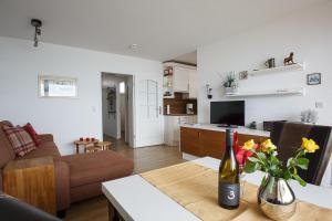 Sala de estar con mesa y botella de vino en Haus Uthlande Uthlande Whg 51 Meeresbrise, en Wyk auf Föhr