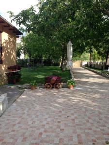 un giardino con un carrello con fiori e un ombrello di Agriturismo Capriccio Di Giove a Cansano