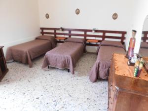 a room with three beds and a table in it at La casa di Mascia in Roccasecca