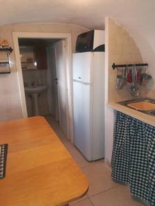 a kitchen with a white refrigerator and a sink at Vico Anglani Guest House in Ostuni