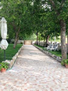 einen Weg mit Sonnenschirm, Stühlen und Bäumen in der Unterkunft Agriturismo Capriccio Di Giove in Cansano