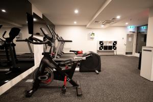 a gym with a exercise bike and a treadmill at Movenpick Hotel Melbourne On Spencer in Melbourne