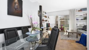 a dining room with a glass table and black chairs at Apartment Sabin - Llafranc in Llafranc