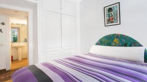 a white room with a bed with a purple blanket at Apartment Sabin - Llafranc in Llafranc