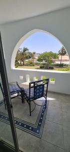 d'une terrasse avec une table, des chaises et une fenêtre. dans l'établissement Apartment at domina coral bay aquamarine , resort spa e casino', à Charm el-Cheikh
