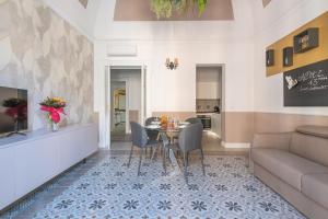 Una sala de estar con una mesa y sillas y un sofá. en Nitti43 luxury apartment, en Taranto