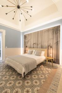 Un dormitorio con una cama grande y una lámpara de araña. en Nitti43 luxury apartment, en Taranto