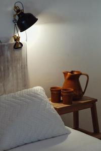 a bed with a table with a lamp and some pots on it at Kačara Vodeničko brdo in Pranjani