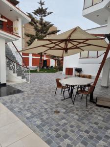 un tavolo e sedie con ombrellone su un patio di Hotel Costa Andina a Moche