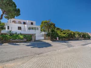 ein weißes Haus mit einer Auffahrt davor in der Unterkunft Carvoeiro Peaceful Villa with Pool in Carvoeiro