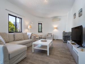 ein Wohnzimmer mit Sofa und Fernseher in der Unterkunft Carvoeiro Peaceful Villa with Pool in Carvoeiro