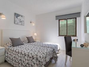 ein Schlafzimmer mit Bett, Schreibtisch und Fenster in der Unterkunft Carvoeiro Peaceful Villa with Pool in Carvoeiro + 12 Fotos