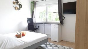 1 dormitorio con cama, ventana y TV en Ch privée 14m - Netflix - Wifi - Appart' 120m, en Woippy