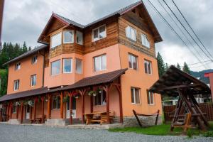 a large orange building with a gambrel roof at Cabana Liliana in Arieşeni