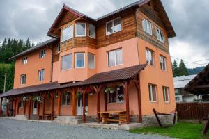 a large orange building with a wooden roof at Cabana Liliana in Arieşeni +21 photos