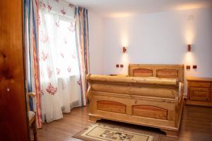 a bedroom with a wooden bed and a window at Cabana Liliana in Arieşeni