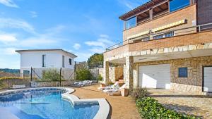 een huis met een zwembad naast een gebouw bij Villa Sote - Lloret de Mar in Vidreres