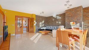 een eetkamer en een woonkamer met een bakstenen muur bij Villa Sote - Lloret de Mar in Vidreres