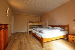 1 dormitorio con 1 cama y suelo de madera en Ferienwohnung Steinberg mit Sauna, en Wernesgrün