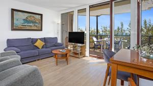ein Wohnzimmer mit einem blauen Sofa und einem TV in der Unterkunft Apartment SPal - Blanes in Blanes