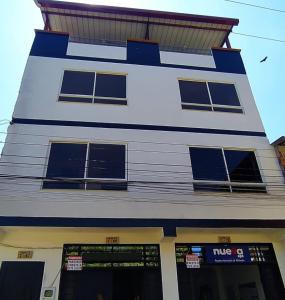 CASA TOÑITA في Oiba: مبنى أبيض كبير مع تقليم الأزرق والنوافذ