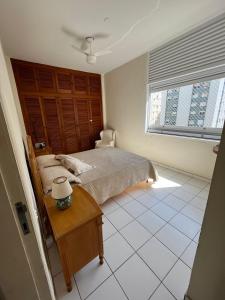 - une chambre avec un lit, une table et une fenêtre dans l'établissement APARTAMENTO NA RUA DA PRAIA COM VISTA PARA O MAR, à Guarujá