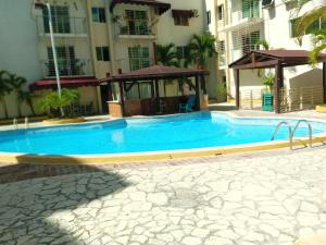 a large blue swimming pool next to a building at Apartamento en BOCA CHICA, a 50 metros, playa boca chica in Boca Chica